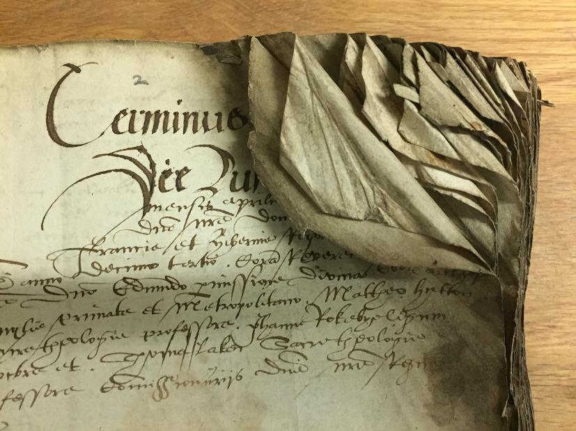 Top right-hand corner of a 16th century High Commission Act Book with corners folded in and obscuring writing.